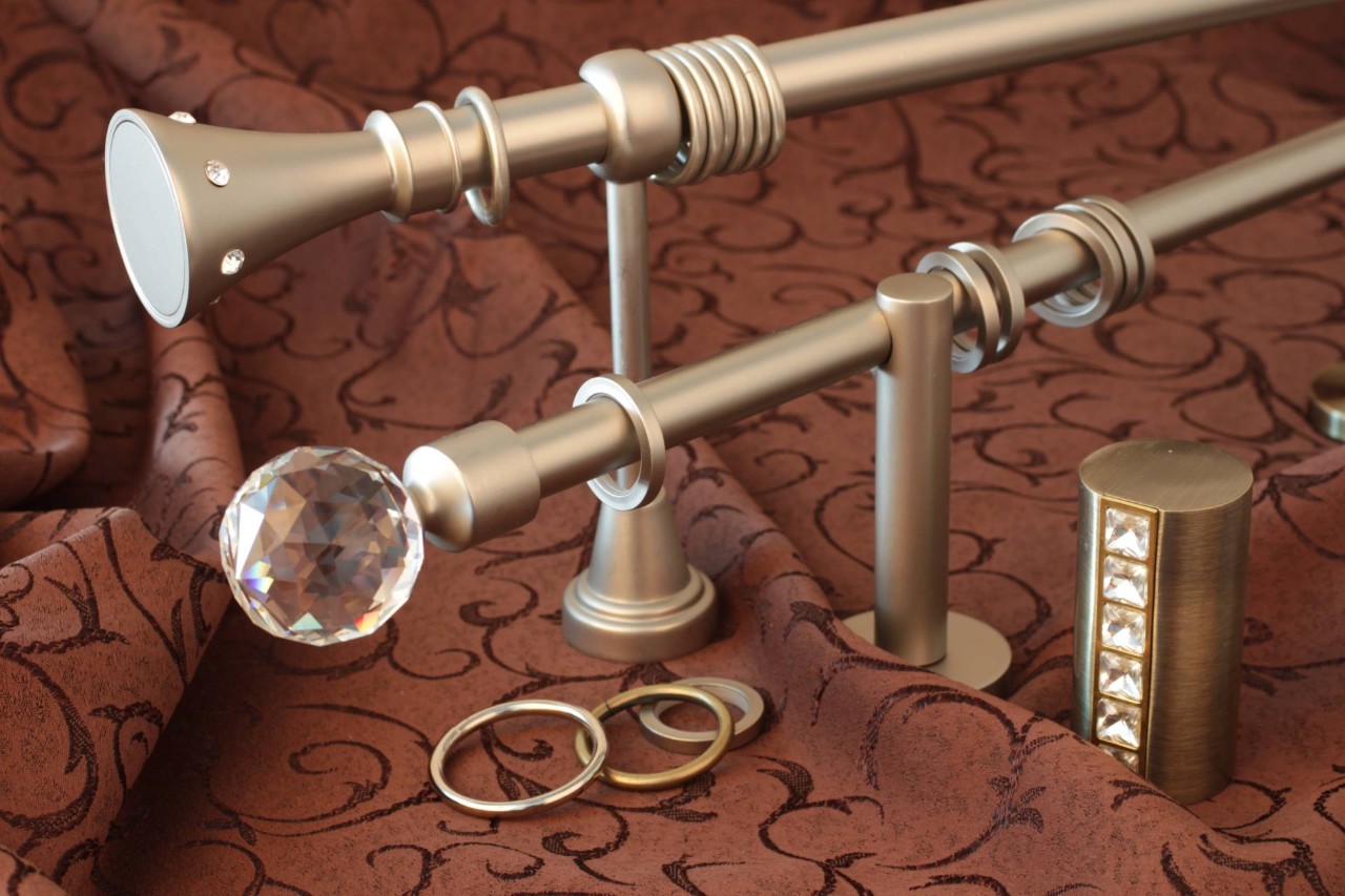 Beautiful metal curtain rods set on top of red fabric for display near Jupiter, FL