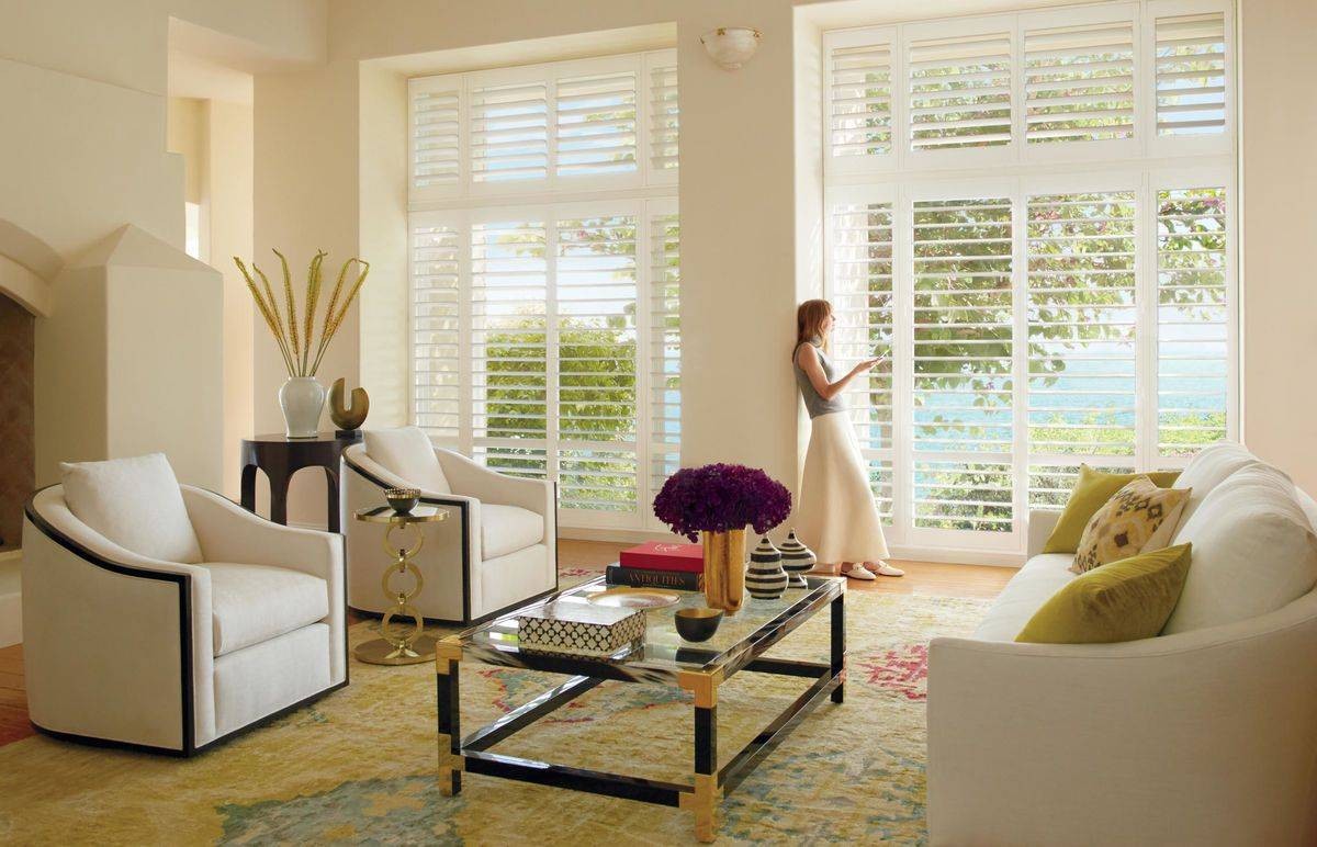 Bright and airy living room with Hunter Douglas Palm Beach™ Polysatin™ Shutters decorating the windows near near Jupiter, Florida